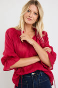 Woman wearing a red among the brave blouse with ruffled sleeves on a white background