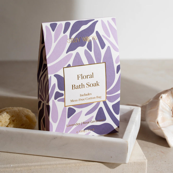 Floral bath soak packaging with purple leaf pattern on a neutral background