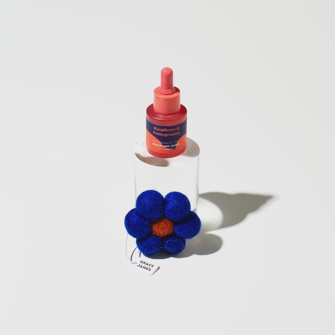 Bottle of red liquid with a blue flower on a white background