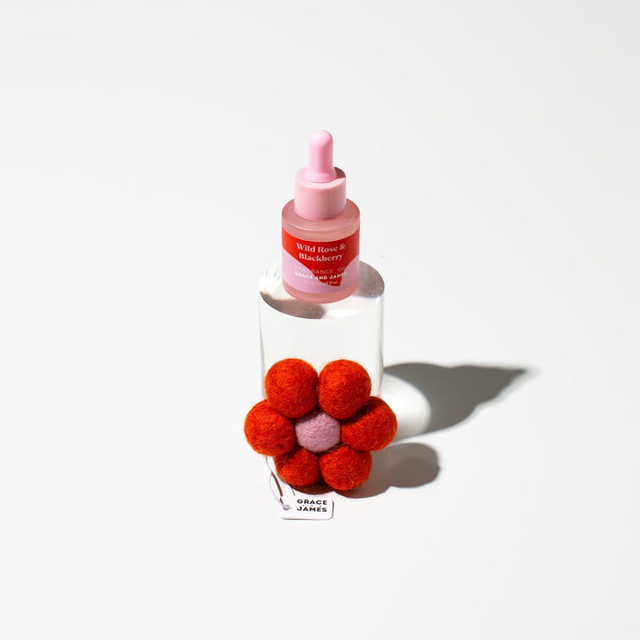 Clear bottle with red flower-shaped cap on a white background