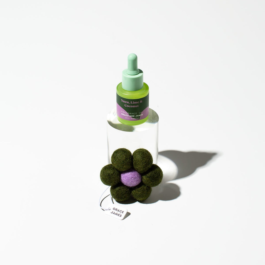 Bottle of air freshener product with a flower-shaped container on a white background