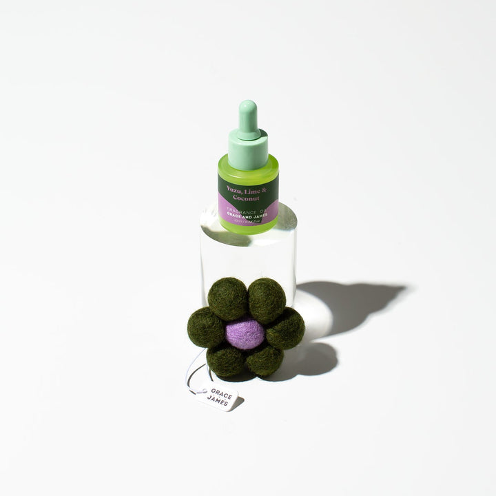 Bottle of air freshener product with a flower-shaped container on a white background