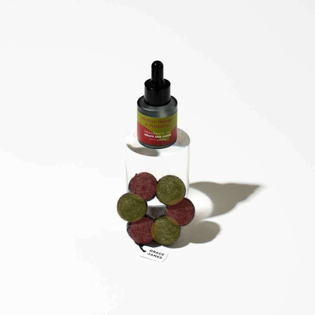 Bottle with a dropper and green and red丸s on a white background