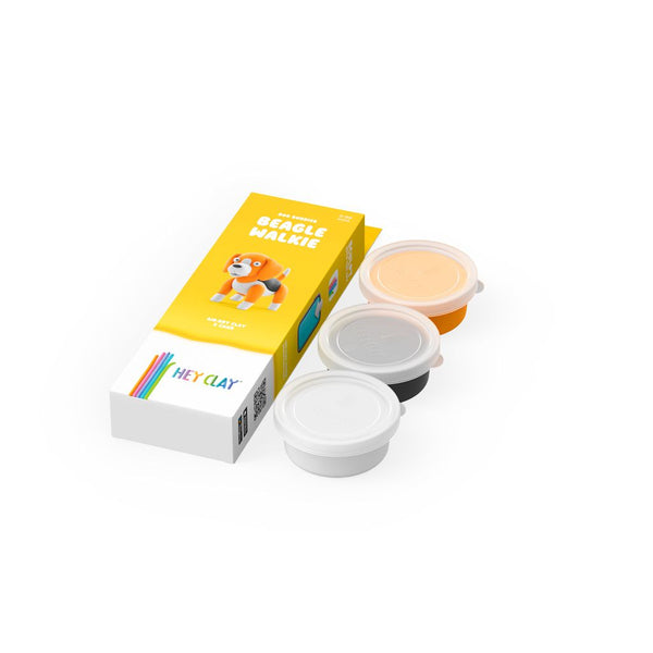 Packaging of Hey Clay modeling clay with a yellow box featuring a cartoon dog and three clay containers on a white background.