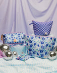 Set of floral-patterned bags on a light purple background with disco balls.