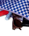 Blue and white checkered pouch with sunglasses and lip balms on a white background