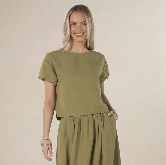 Woman wearing a green outfit on a beige background