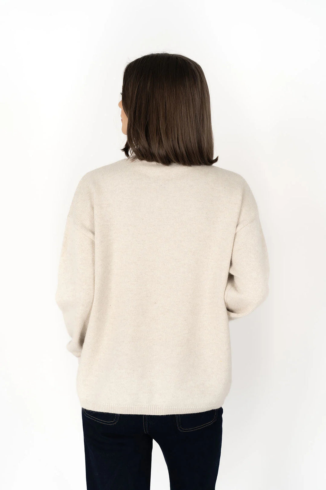 Woman wearing a beige sweater on a white background