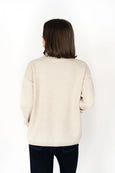 Woman wearing a beige sweater on a white background
