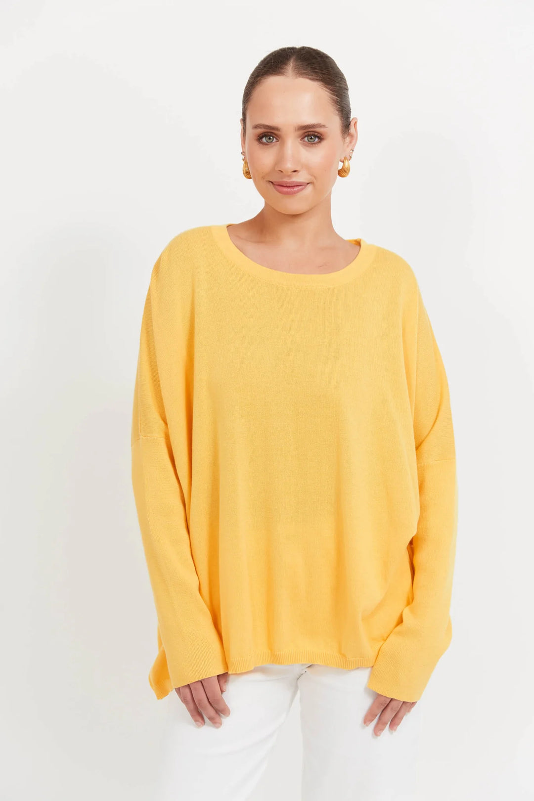 Woman wearing a yellow haven sweater against a white background