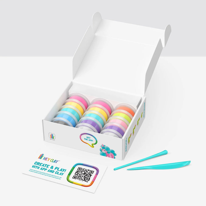 Box of colorful clay rolls with a tool on a white background