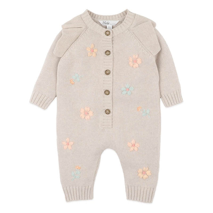 Beige baby romper with floral patterns on a white background