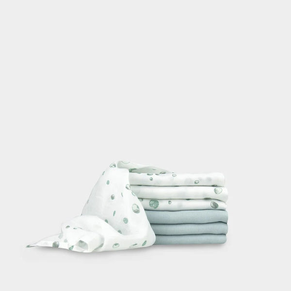 Stack of folded fabric with a white and green pattern on a light gray background