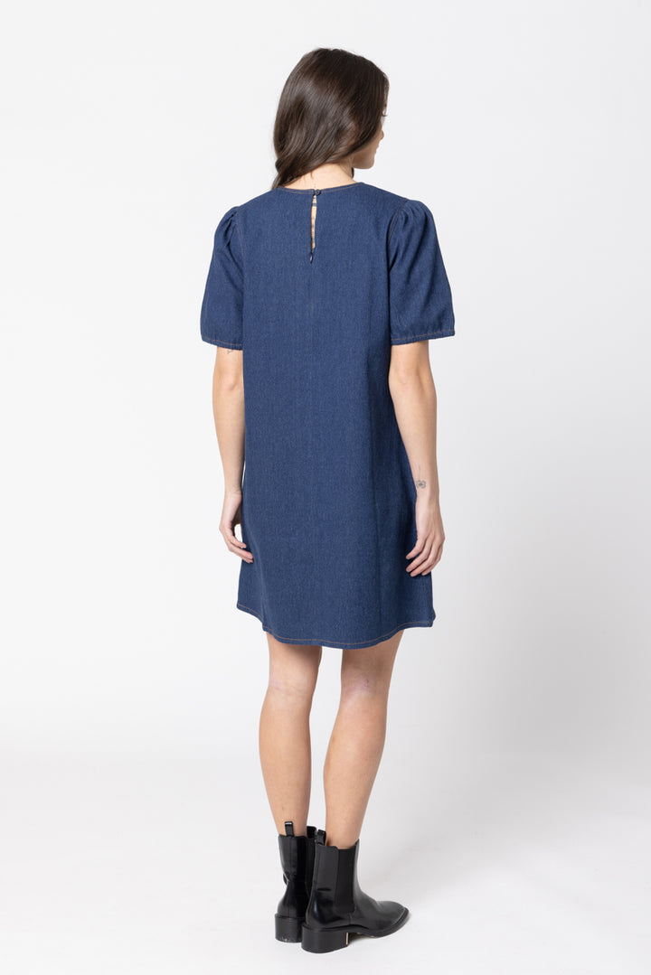 Woman wearing a blue drifter  dress on a white background