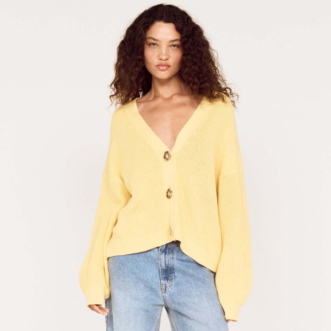 Woman wearing a yellow blouse and blue jeans on a white background