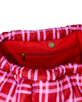 Close-up of a red bag with pink plaid lining and gold zipper.