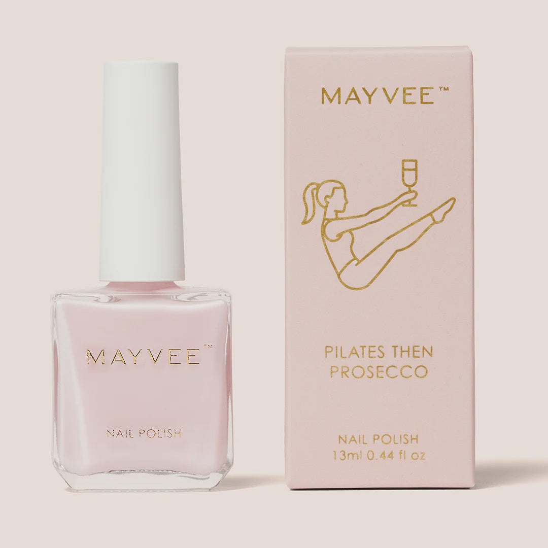 Mayvvee nail polish bottle in pale pink next to its light pink packaging box with gold lettering, on a solid pale beige background.