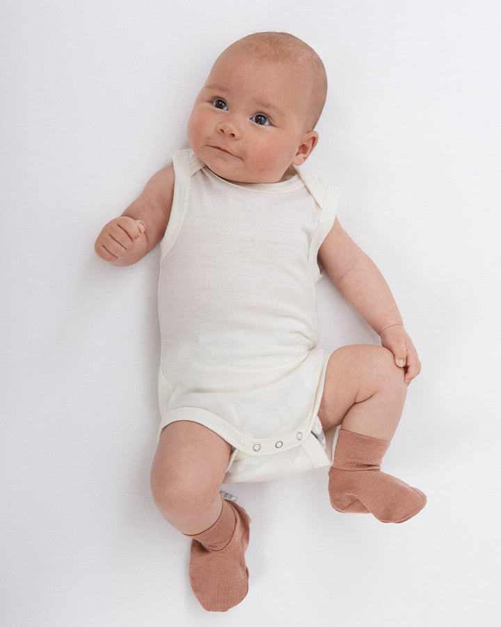 Merino Singlet Bodysuits are perfect for wearing on their own in the warmer months or for layering up in cooler seasons without restricting arm movement. Available from www.thecollectivenz.com