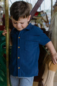 Young boy in Milky blue shirt standing on a carousel