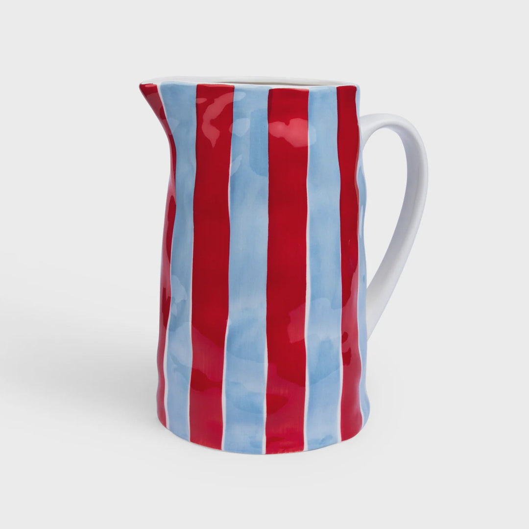 Ceramic pitcher with red and blue striped design on a white background