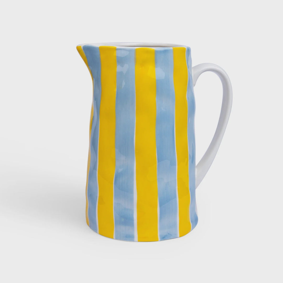 Ceramic pitcher with blue and yellow striped design on a white background