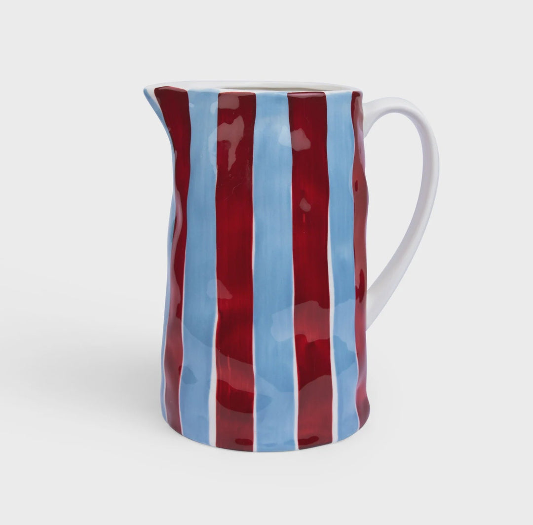 Striped ceramic pitcher with red and blue pattern on a white background
