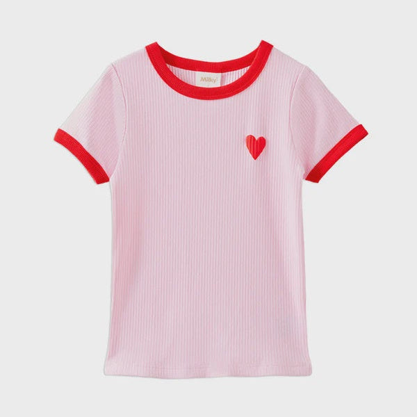 A light pink ribbed short-sleeve t-shirt with red trim on the collar and sleeve cuffs, featuring a small red heart on the left chest, displayed against a light gray background.