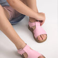 Person wearing pink pretty brave sandals on a white background