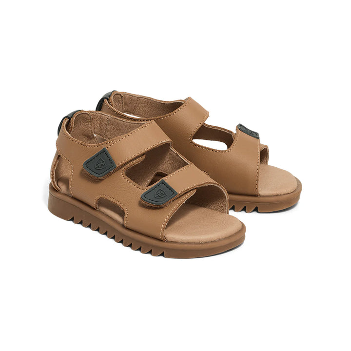 Pair of Pretty brave tan children's sandals with green buckles on a white background