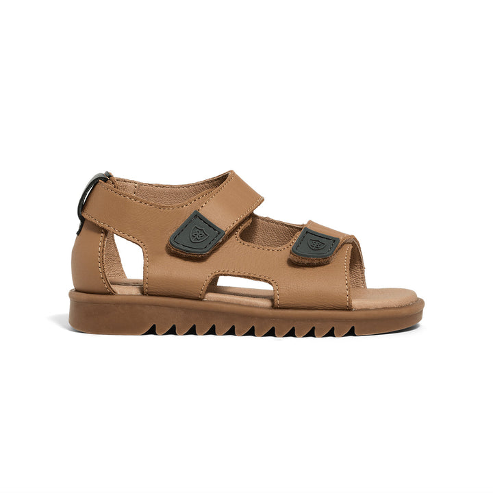 Tan Pretty Brave sandal with black straps on a white background