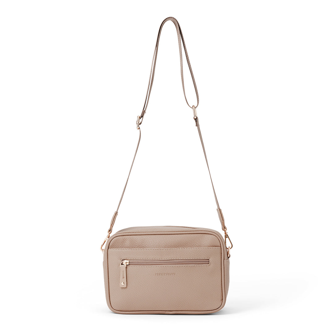 Pretty Brave beige crossbody nappy bag on a white background