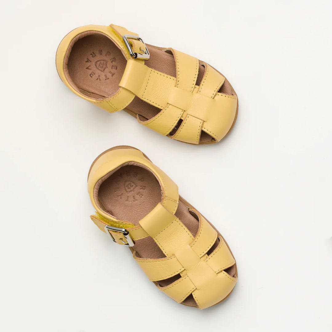 Pair of yellow pretty brave sandals on a white background