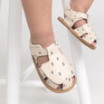 Beige pretty brave sandals with small blue patterns worn by a child on a white background