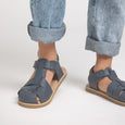 Navy Pretty Brave sandals worn with rolled-up jeans on a light background