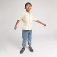 Child wearing a light-colored shirt and blue jeans on a white background