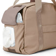 Pretty Brave beige nappy bag with a pocket containing white items on a white background