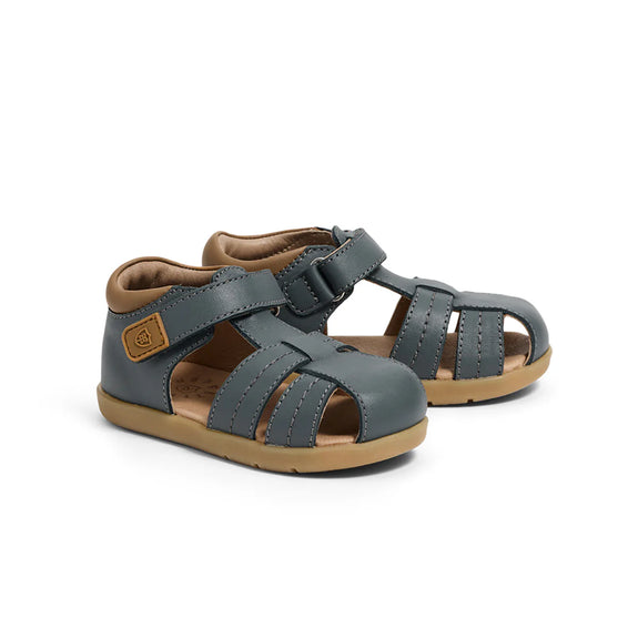 Pair of pretty brave navy sandals with brown soles on a white background