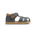 Gray sandal with brown sole and strap on a white background