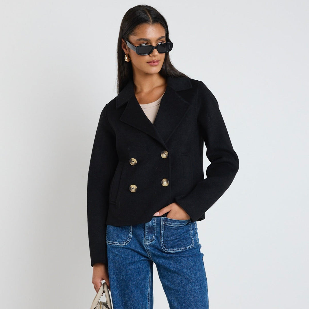 Add a touch of sophistication to your wardrobe with the Prestige Short Black Marle Coat. Crafted from a premium wool blend, this coat features a tailored silhouette with a double-breasted button front, making it a timeless piece for layering. Available from www.thecollectivenz.com