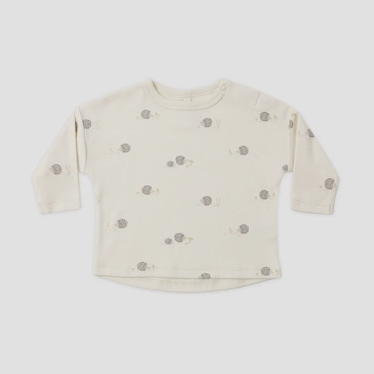 A cream-colored long-sleeve baby top with a small gray and beige animal print, laid flat against a light gray background.