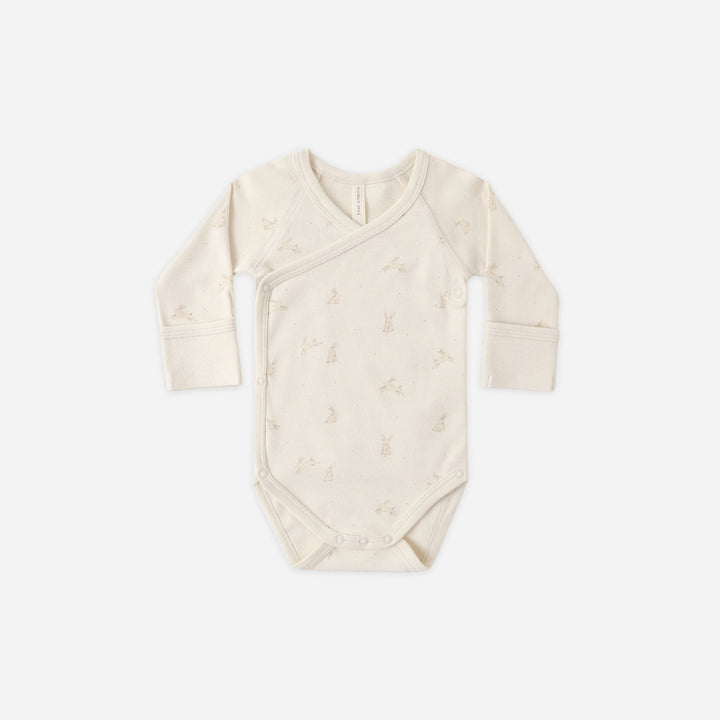 Beige baby bodysuit with long sleeves on a white background