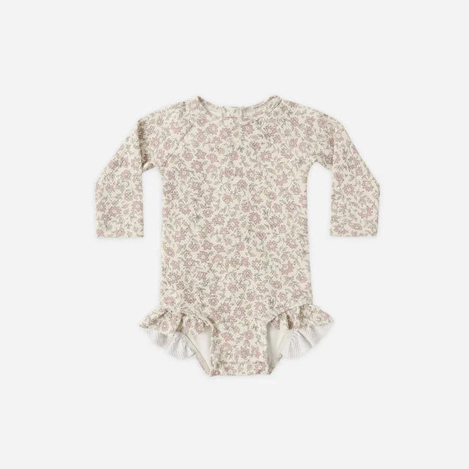 Floral patterned baby onesie on a white background