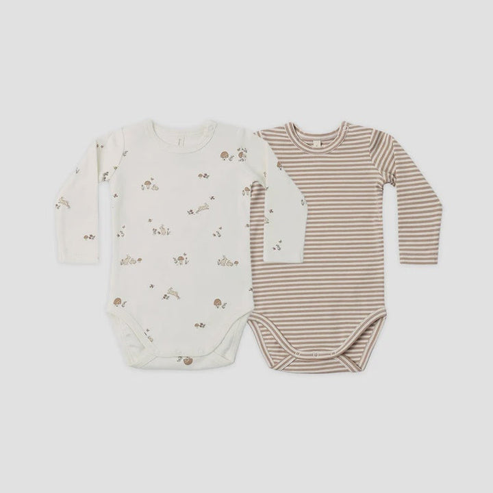 Two long-sleeve baby bodysuits laid flat on a light gray background. The left bodysuit is off-white with small scattered brown animal and floral prints.