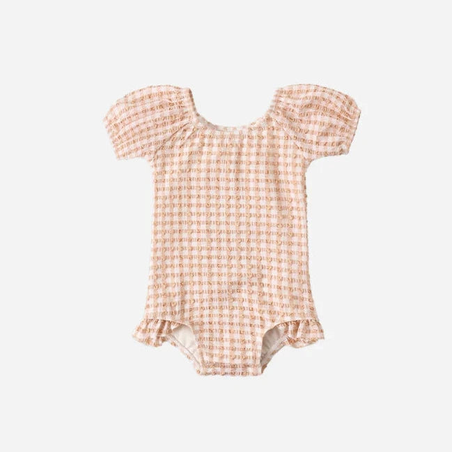 Checkered baby romper on a light gray background