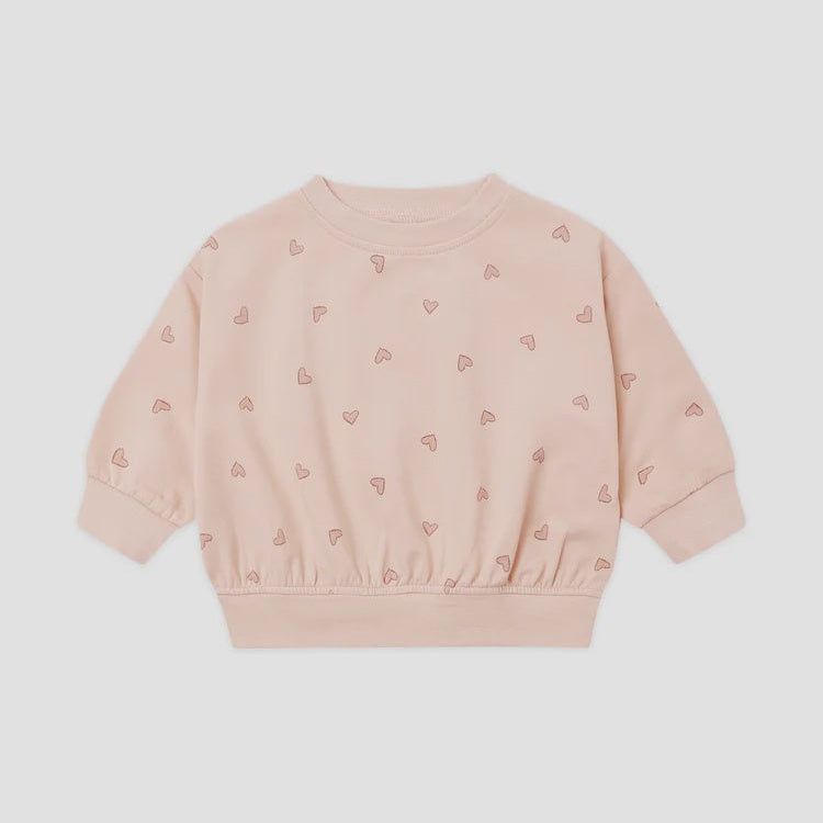 A light pink long-sleeve crewneck sweatshirt with a subtle all-over pattern of small embroidered hearts, displayed flat against a light gray background.