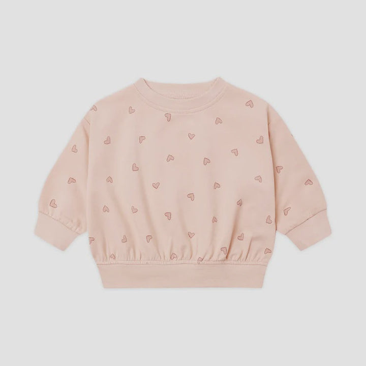 A light pink long-sleeve crewneck sweatshirt with a subtle all-over pattern of small embroidered hearts, displayed flat against a light gray background.