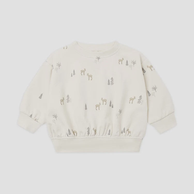 An off-white long-sleeve crewneck sweatshirt for toddlers, featuring a delicate all-over print of small deer and trees in muted brown and gray tones, displayed on a light gray background.