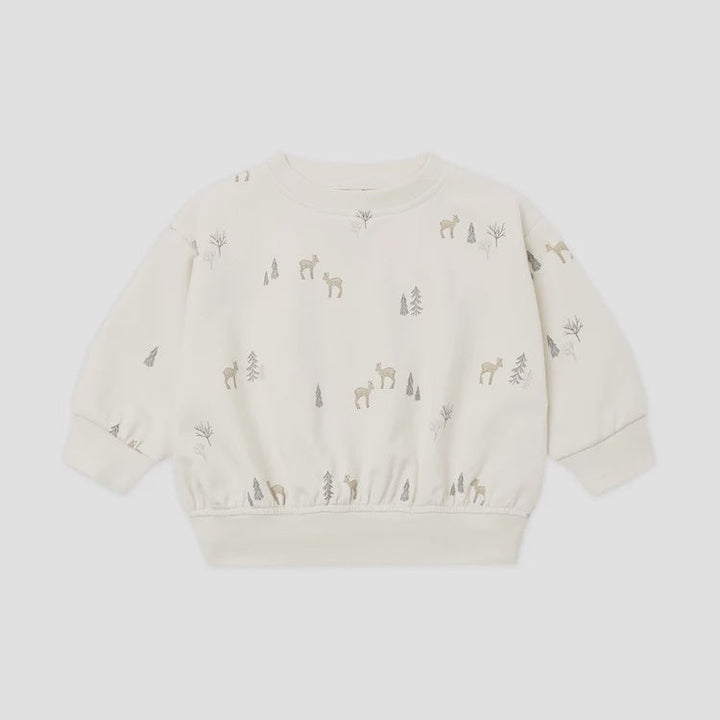An off-white long-sleeve crewneck sweatshirt for toddlers, featuring a delicate all-over print of small deer and trees in muted brown and gray tones, displayed on a light gray background.