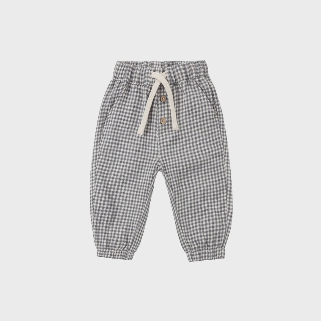 A pair of children's jogger pants in a gray and white gingham check pattern, featuring an elastic waistband with a cream-colored drawstring and side pockets, shown flat on a light gray background.