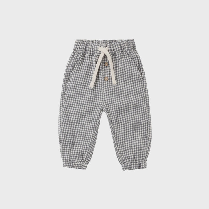 A pair of children's jogger pants in a gray and white gingham check pattern, featuring an elastic waistband with a cream-colored drawstring and side pockets, shown flat on a light gray background.